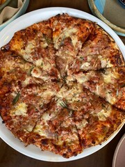 Gourmet pizza served on the white plate on the table 