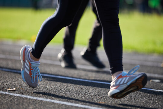 Woman running on a track outdoors. Feet of female runner in motion. Kyiv - 19 October,2024