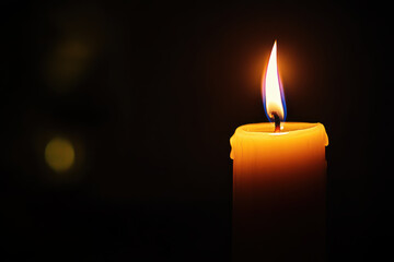 glowing candle with vibrant flame illuminates darkness, creating warm and serene atmosphere. soft light adds touch of tranquility to any setting
