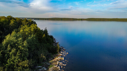 The photo shows the lake with christmas trees on the shore