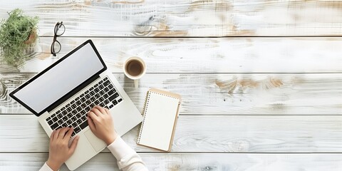 Top view banner with female hands working at a laptop on a white table with space for text.