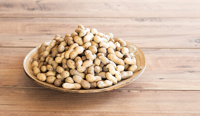 Many fresh unpeeled peanuts as background.