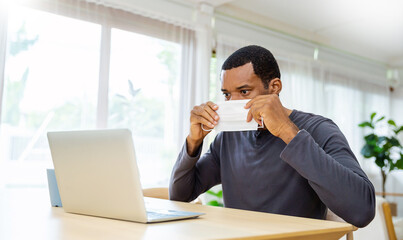 Portrait of sme business African black man in wears medical protective mask working from home at...