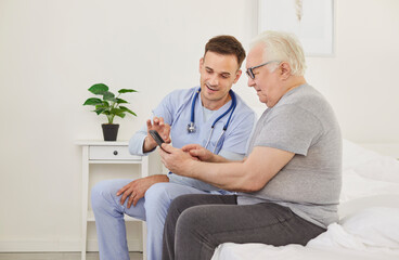 Senior patient learning to use a health care app on a mobile phone. Chubby overweight old man and a friendly young doctor in a uniform with a stethoscope sitting on a bed using a modern phone together