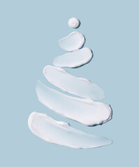 The concept of a Christmas tree in the form of cosmetic touches on a blue background. Winter concept. Skin care.