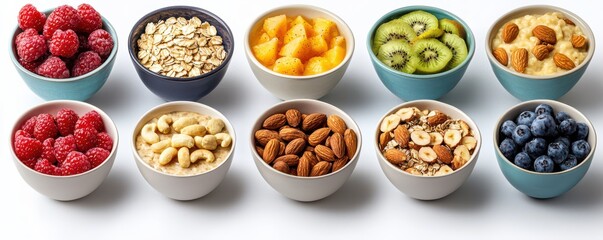 Assorted bowls filled with a variety of fruits, nuts, and grains including raspberries, blueberries, almonds, and oats on a white background