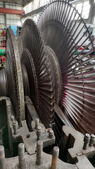 Disassembled steam turbine in the process of repairing and electric generator at power plant