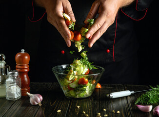 Chef hands stir fresh vegetables for breakfast on the kitchen counter. Restaurant or hotel service concept.
