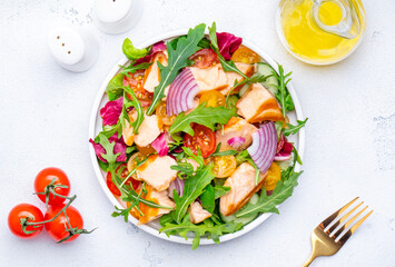 Salad with grilled trout and vegetables, arugula, radicchio, onion and lettuce. White background, top view