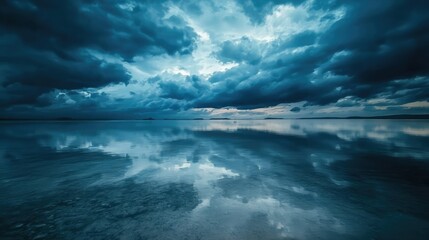 Fototapeta premium A moody sky over a wide expanse of water, with dark clouds gathering and their reflections shimmering on the surface