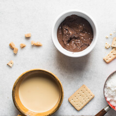 Overhead view of mise en place for making chocolate fudge with cookies and fudge pieces, Top view of ingredients of hazelnut chocolate fudge