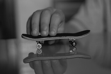 skate de dedos para juego de niños con trucos y dedos de niño jugando con el en mesa de casa de cristal