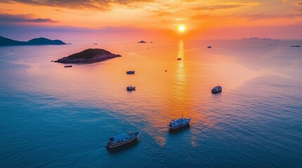 The setting sun shines on the sea, casting warm hues across its surface as boats float gently in the water. The sky is painted with vibrant orange and pink colors that blend seamlessly into each o