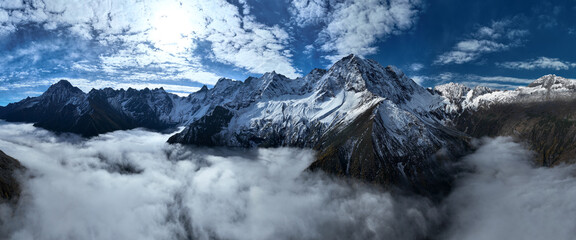 Aerial view of beautiful snow capped mountains and autumn forest landscape