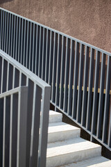 Staircase leading to the entrance of a multi-story residential building surrounded by simple architecture and modern design elements