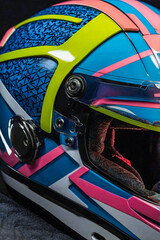Fototapeta premium This vibrant racing helmet showcases a bold geometric design in blue, pink, yellow, and white, with an aerodynamic shape and sleek lines. details enhance its visual appeal, ensuring high performance.