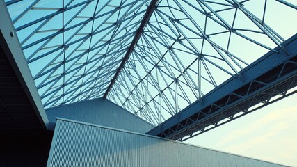 Obraz premium A structural marvel of steel and glass, a modern architectural design with a complex network of beams supporting a skylight