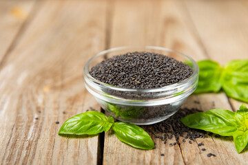Basil seeds on textured wooden background. Close-up. Superfood. Ocimum basilicum. Organic basil seeds. selasih. Space for text. Copy space.