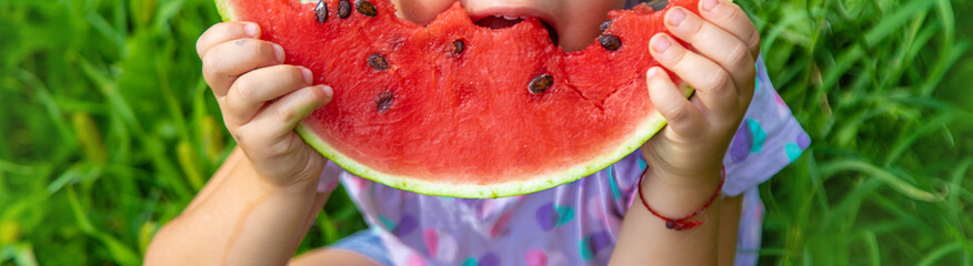 Child eats watermelon in summer. Selective focus.