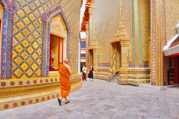 Fototapeta premium A Thai monk is walking in a beautiful craftsmanship and famous Buddhist temple of Wat Ratchabophit Sathitmahasimaram Ratchaworawihan in Bangkok, Thailand. A symbol of belief and worship in Buddhism