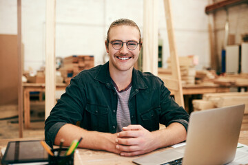 Carpentry, laptop and portrait of man in warehouse for manufacturing, building and furniture production. Woodworking, workshop and carpenter on computer for timber, lumber or construction business