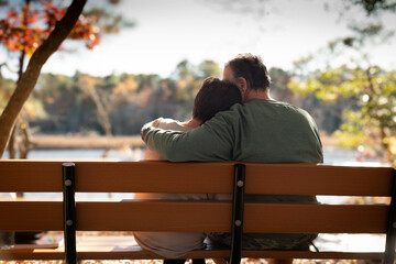 A senior couple in love embracing on a park bench