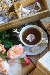 Beautiful roses, a cup of tea and many books on the table