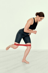 Obraz premium Fitness Trainer Performing Resistance Band Kickback Exercise