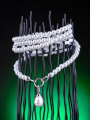 Close up of a string of white pearls necklace on a dark background