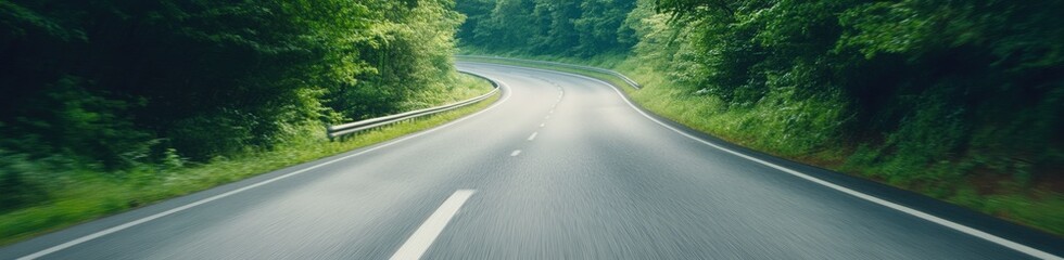 Fototapeta premium Winding road through lush green forest landscape