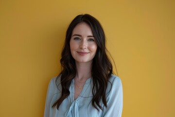 Fototapeta premium Confident Professional Woman with Long Dark Hair Against Yellow Wall for Business Profile