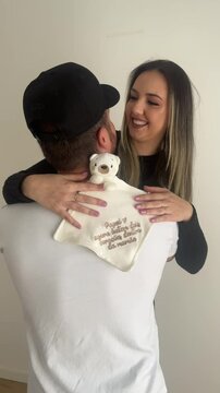casal abra&ccedil;ados com ursinho comemora gesta&ccedil;&atilde;o 