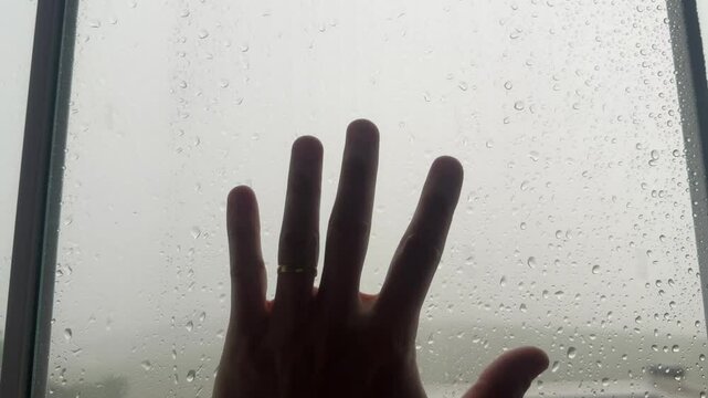 m&atilde;o na janela gotas de &aacute;gua da chuva caindo 