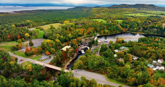 Picturesque autumn panorama of the river with a waterfall in the middle forest on the background of lake Champlain. Ausable Chasm in upstate New York. Aerial view.