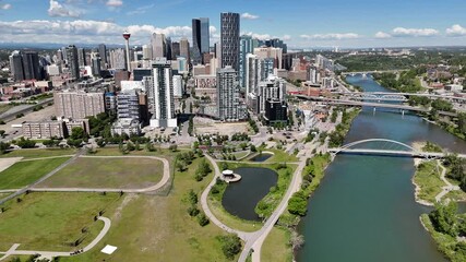 Calgary Alberta Canada, June 18 2024: Downtown skyline aerial turning shot with city centre overlooking river with bridges.
