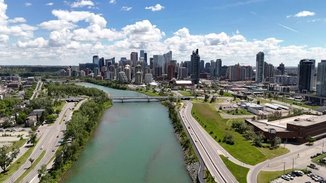 Aerial downtown city skyline with bridge revealing a river flowing between roadways in Calgary Alberta Canada.
