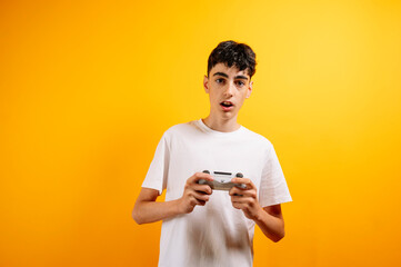 A teenager plays video games on a yellow background.