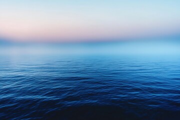 Obraz premium Calm Blue Ocean Under a Foggy Pink and Blue Sky
