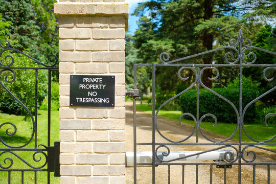 Private property sign seen at the automated entrance to a large, private gated community of luxury houses and apartments.