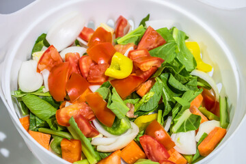 chopped raw vegetables in a white basket.