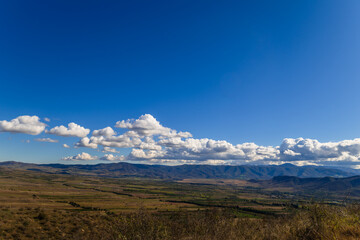 Sunny landscape with beautiful white clouds and settlements, Armenia-Georgia border	