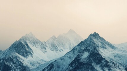 Fototapeta premium Snow-covered mountain peaks under overcast sky at twilight