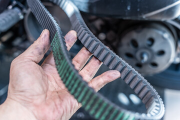 Motorcycle mechanic check the condition of motorcycle transmission belt or Drive belt ,working at garage, maintenance and repair motorcycle concept