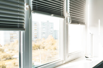 Fototapeta premium Gray blackout roller blinds on window indoors, closeup.