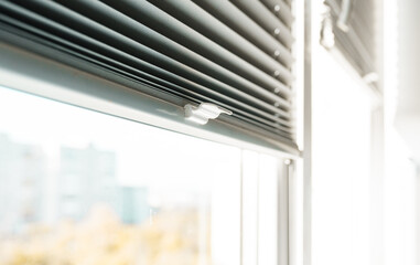 Gray blackout roller blinds on window indoors, closeup.