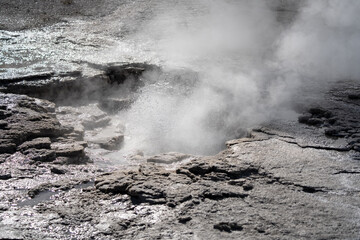 an active geyser spring with an intermittent discharge of water ejected turbulently and accompanied by steam