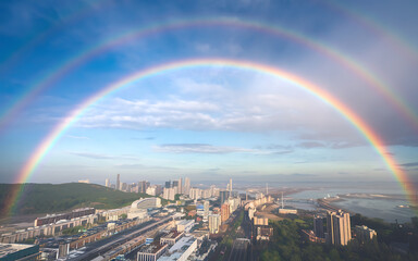 Double rainbow over city skyline  blue and green  hope and renewal  urban landscape   