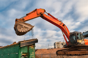 Excavator loads soil in mobile crushing and sorting complex