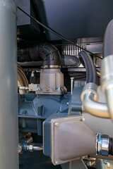 Industrial air compressor showing pipes, valves, and engine components