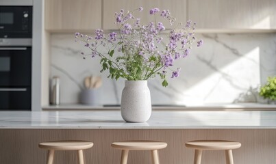 A white vase with purple flowers sits on a kitchen counter